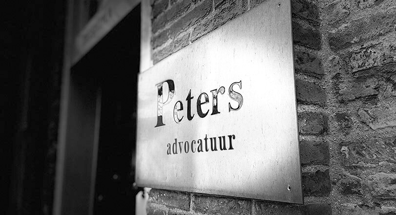 Het messing naambord van Peters Advocatuur naast de voordeur van het kantoor